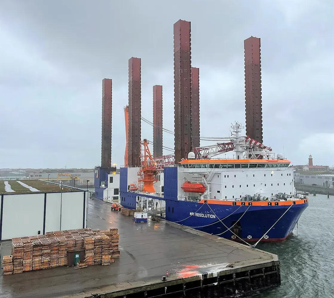 An offshore wind turbine installation vessel with tall jack-up legs.