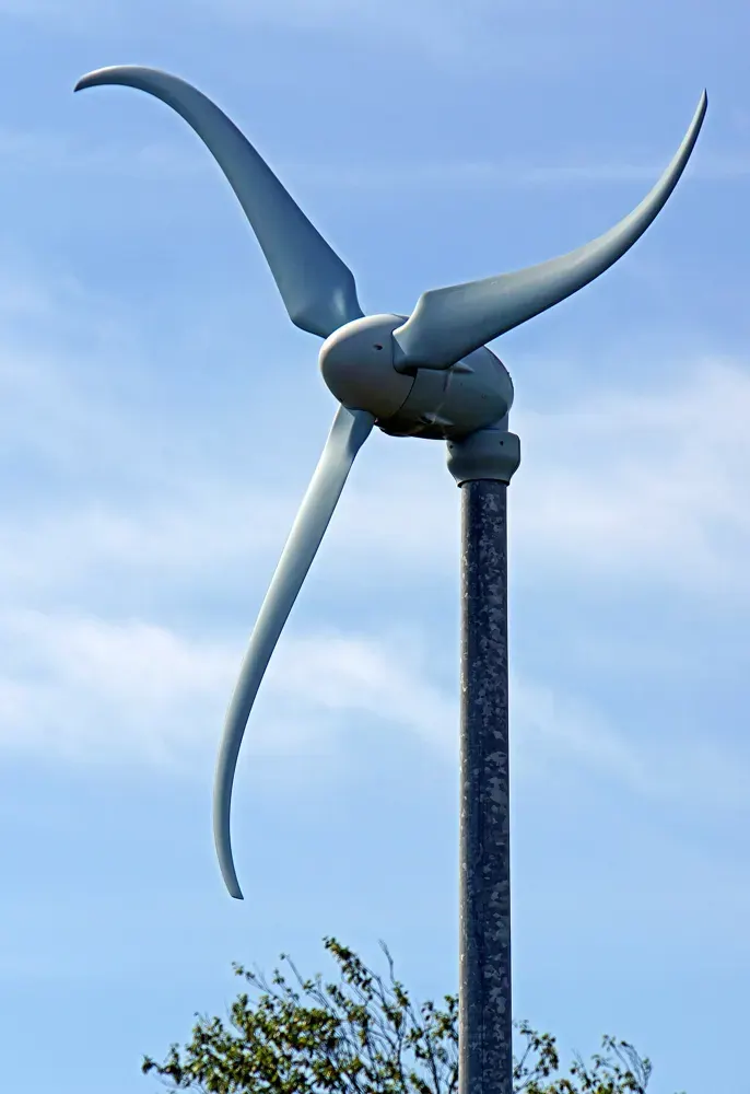 A small curved-blade wind turbine against the sky.