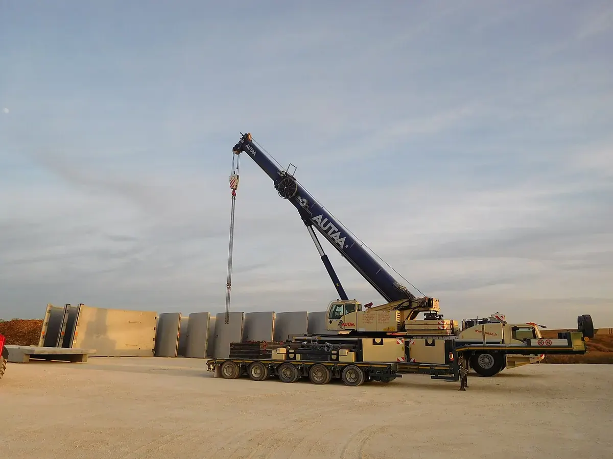 A crane and construction equipment at a wind turbine installation site.