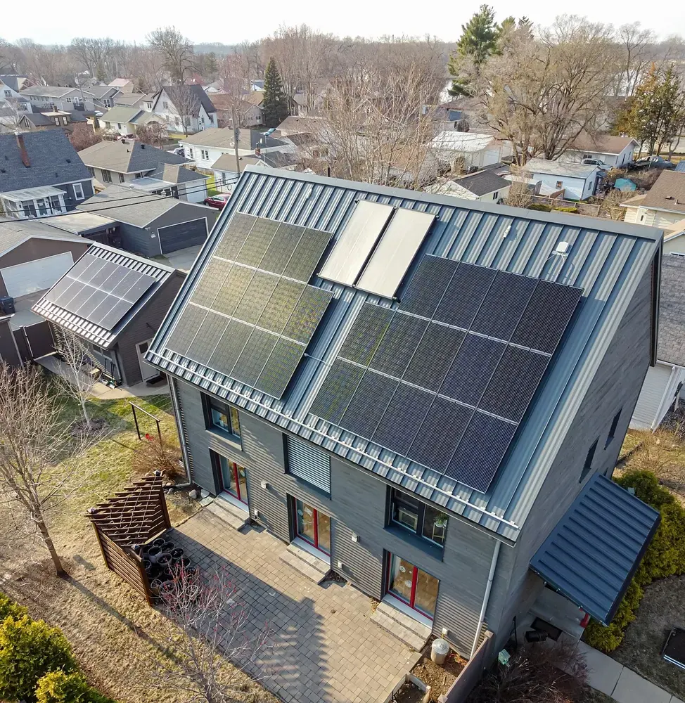 A passive house with a steep solar-clad roof viewed from above.