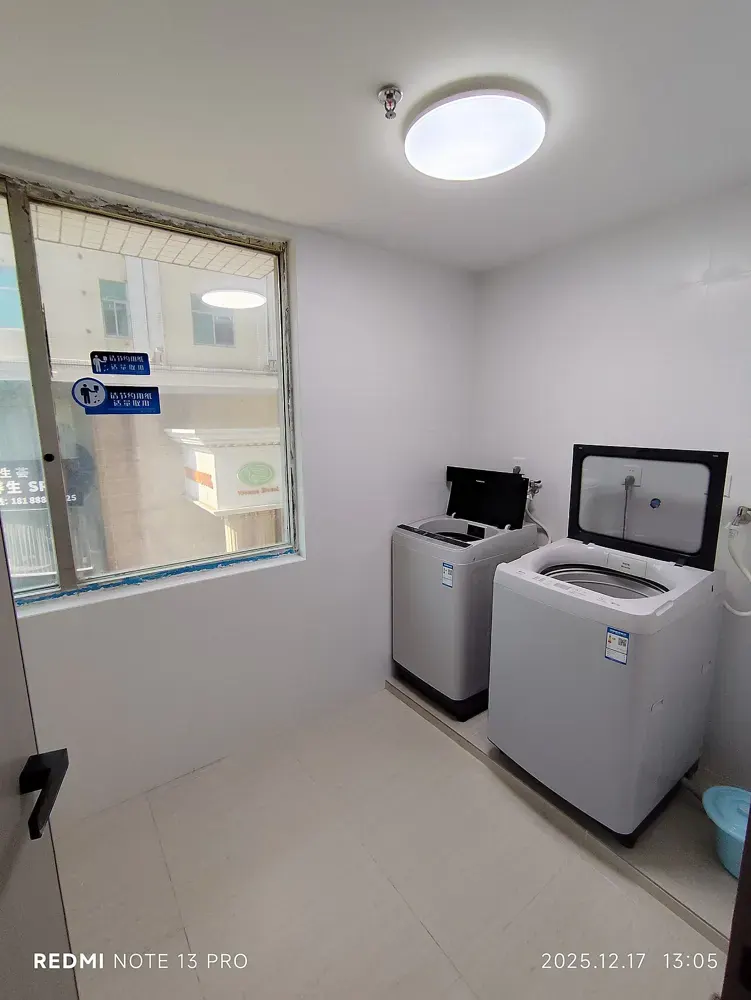 Washing machines in a bright, compact laundry room.