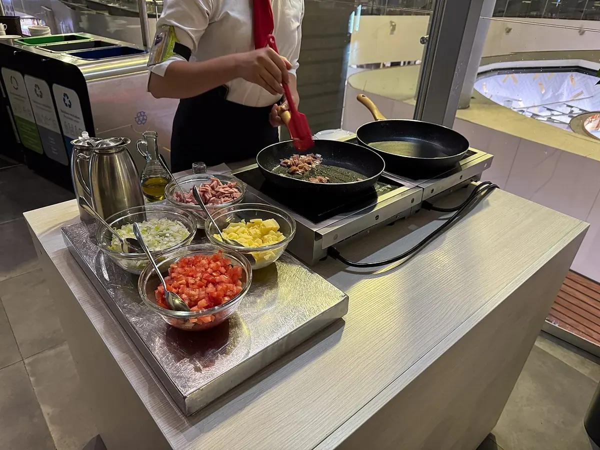 An induction cooking station with cookware and food preparation equipment.
