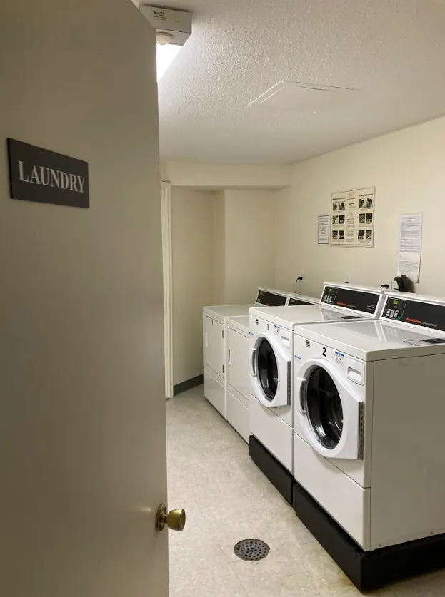 Washing machines in a shared apartment building laundry room.