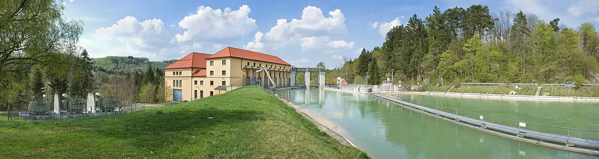 A run-of-river power station beside a green riverbank.