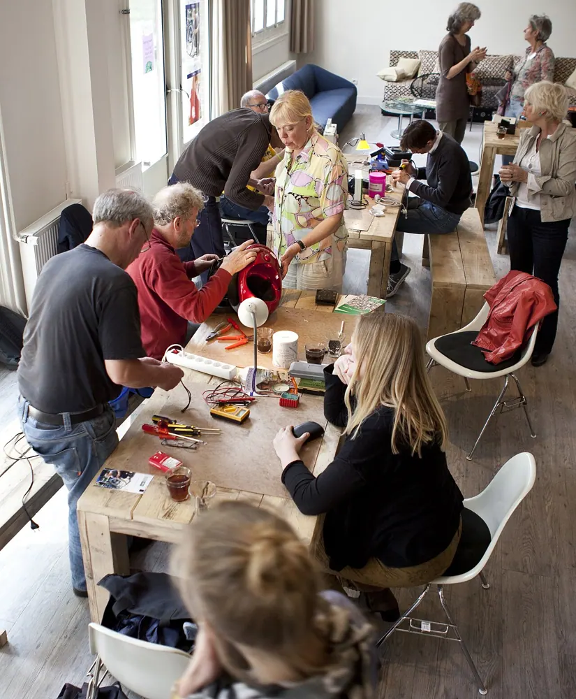 A person works on an appliance at a repair cafe.