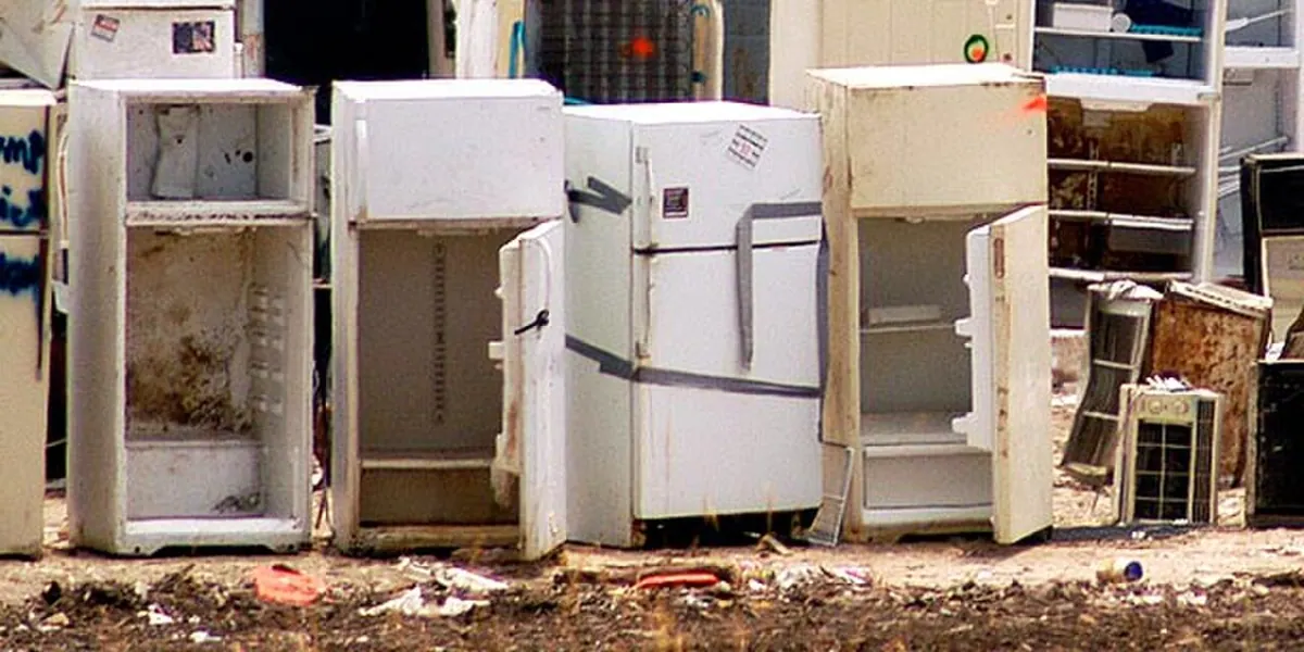 Used household refrigerators await repair or further processing.