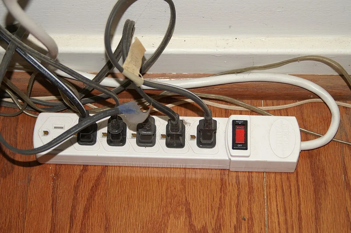 An electrical power strip with several sockets and a switch.