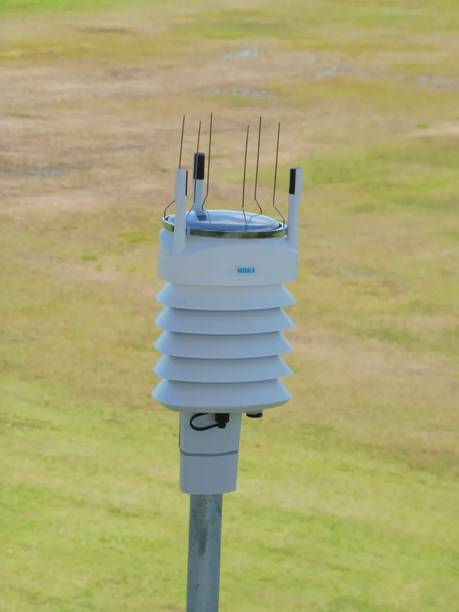 A compact weather station with instruments mounted on a pole.